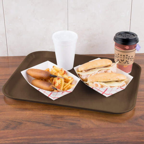 A Carlisle Glasteel tray with hot dogs, a sandwich, coffee, and a white plastic cup with a lid.