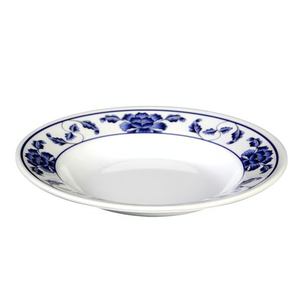 A white melamine soup plate with blue lotus flowers on it.