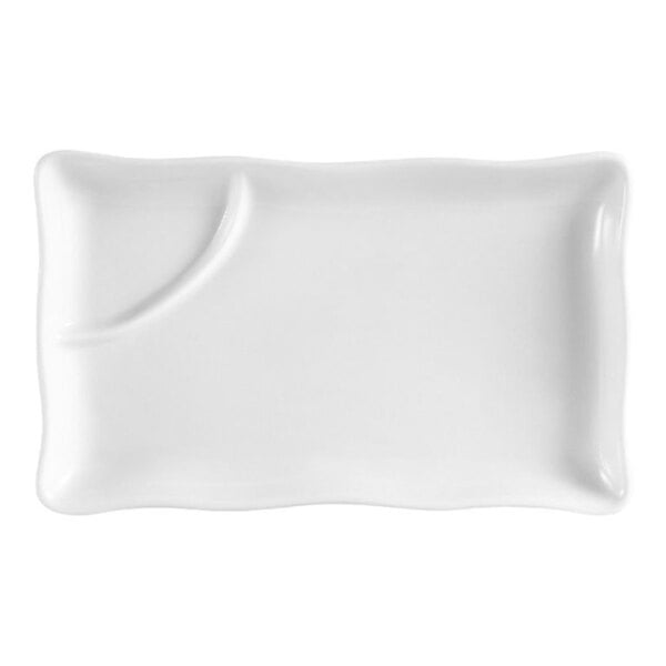 A rectangular white plate with a small curved divider creating a separate section on one side.