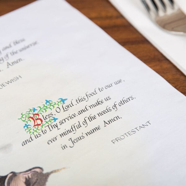 A piece of paper with a menu and a bible verse on a table with a fork and knife.