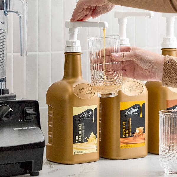 A 64 fl. oz. bottle of DaVinci Gourmet White Chocolate Flavoring Sauce with a pump dispenser.
