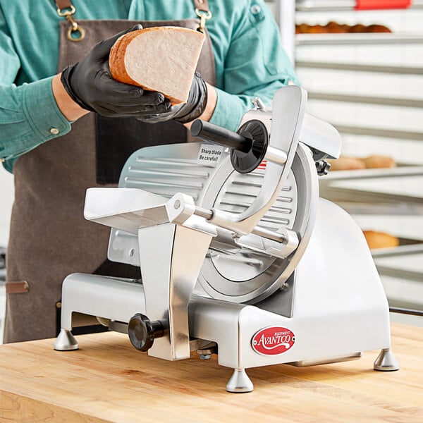 An Avantco meat slicer cutting bread.