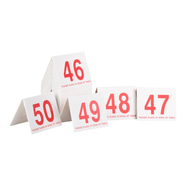 A set of white, tent-shaped cards with large red numbers ranging from 46 to 50, each card displaying the instruction 'PLEASE PLACE AT EDGE OF TABLE' in red text.