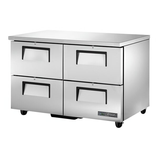 A silver True undercounter refrigerator with four drawers and black handles.
