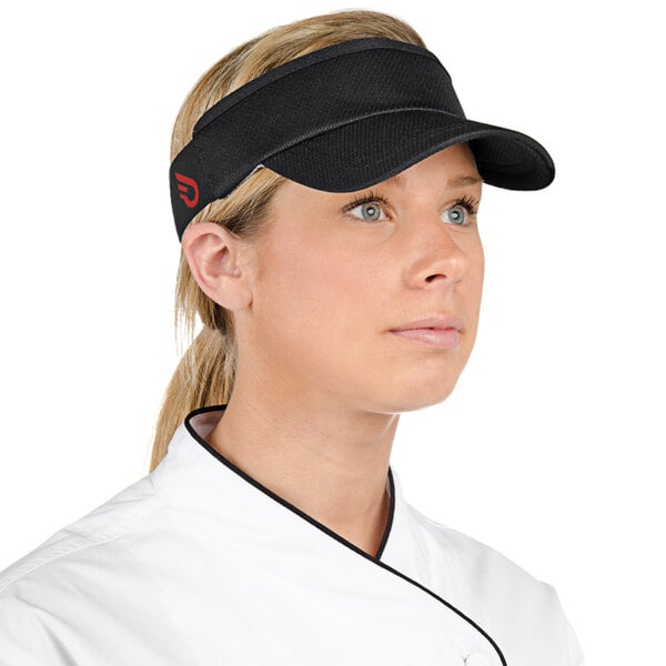 A woman in a chef's uniform wearing a black Headsweats visor.