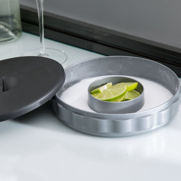 A Tablecraft Margarita Rimmer with lime slices in a circular container.