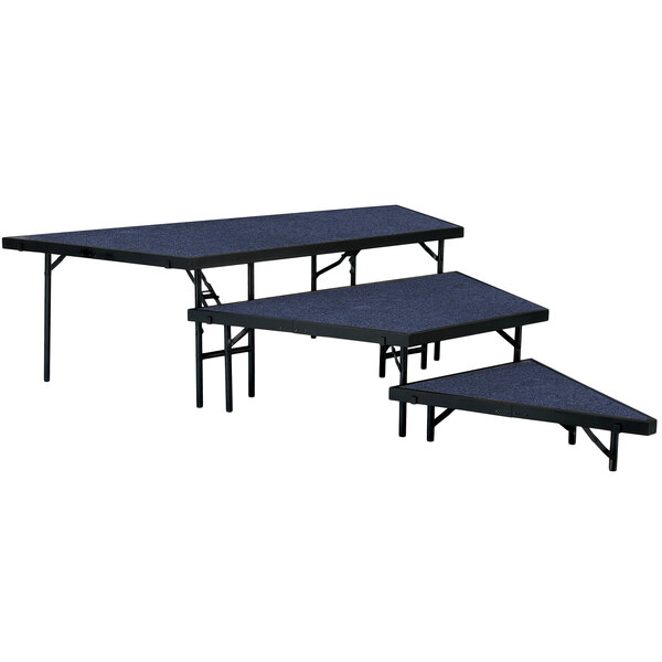 A National Public Seating portable stage pie unit with blue carpet on a table with blue tops.