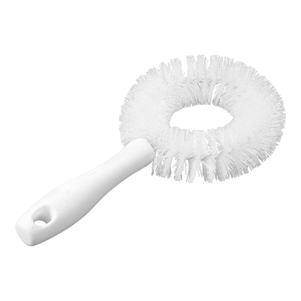 A white brush with a circular arrangement of bristles and a short handle.