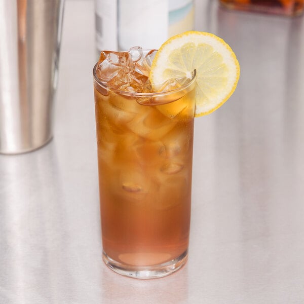 A Libbey straight sided glass of iced tea with a lemon slice.
