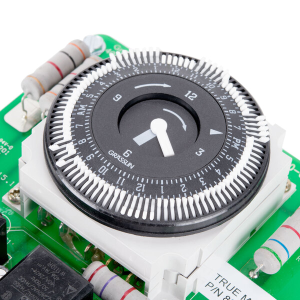 A circular black and white True Defrost Timer dial on a black electronic device.