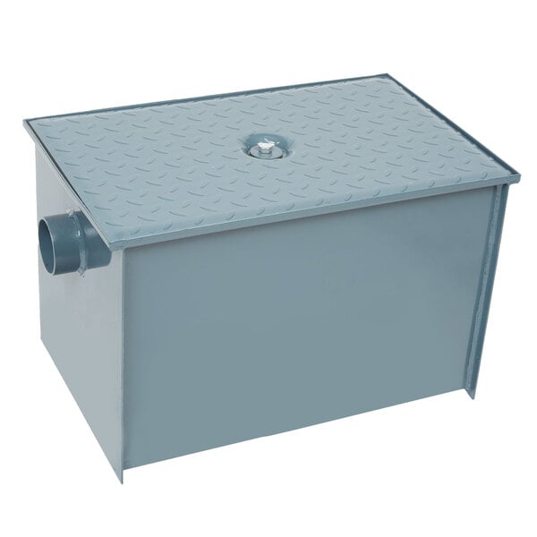 A close-up of a grey metal Watts Grease Trap box with a hole.