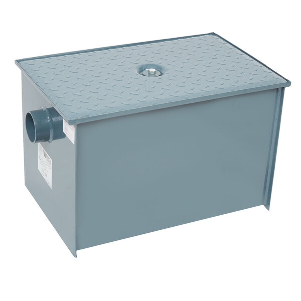 A grey metal Watts grease trap with a hole.