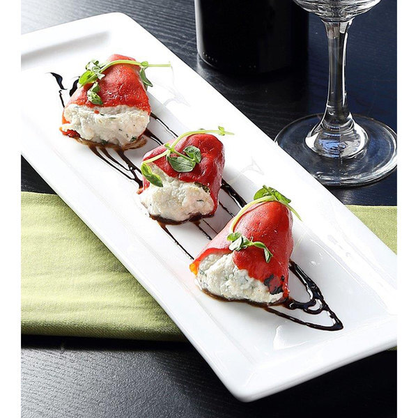 A Tuxton white rectangular china platter with three appetizers on it.