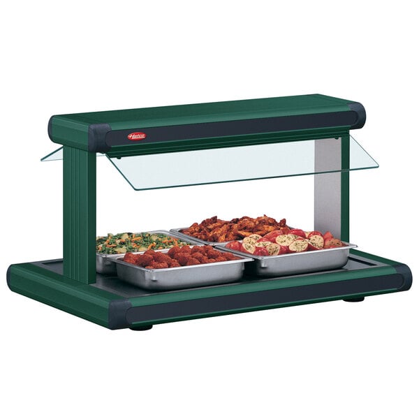 A Hatco buffet food warmer with green and black trays of food on a counter.