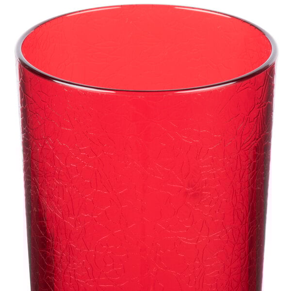 A close up of a red Cambro Del Mar plastic tumbler with a cracked surface.