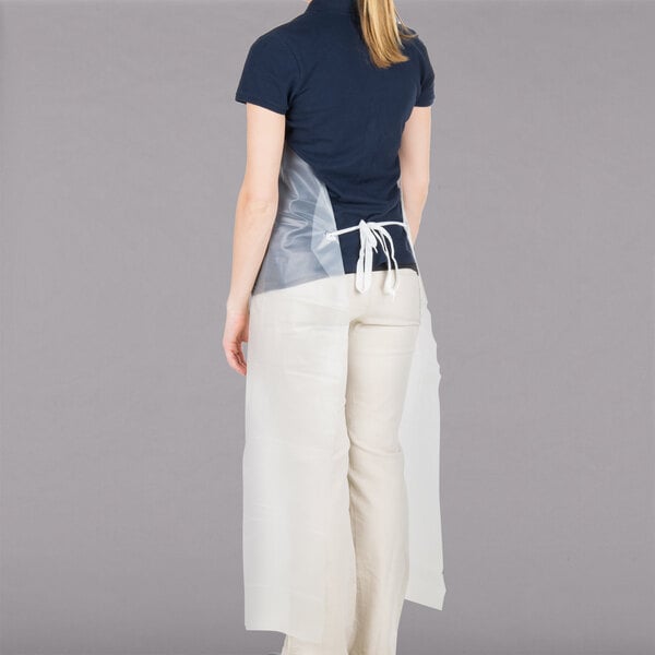 A woman wearing a San Jamar clear vinyl dishwasher apron.