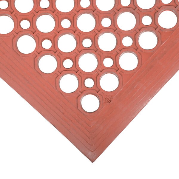 A close up of a red Cactus Mat with holes in it.