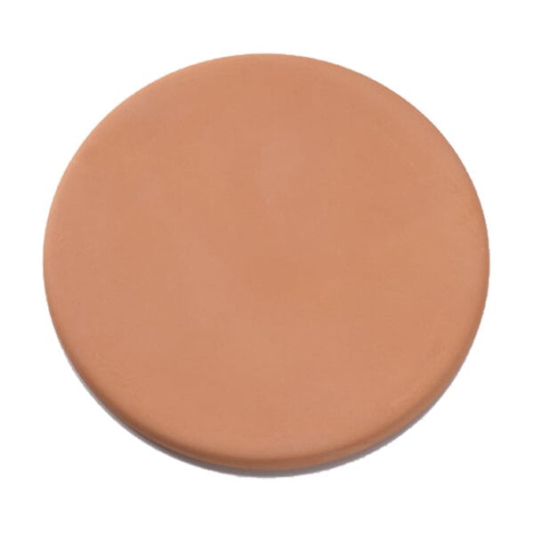A round tan warming stone with a shadow.
