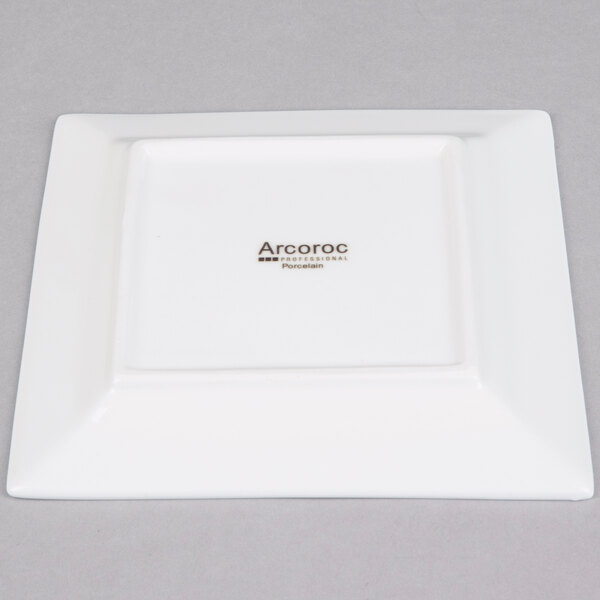 A white square Arcoroc porcelain plate with black text that says "Arcoroc"