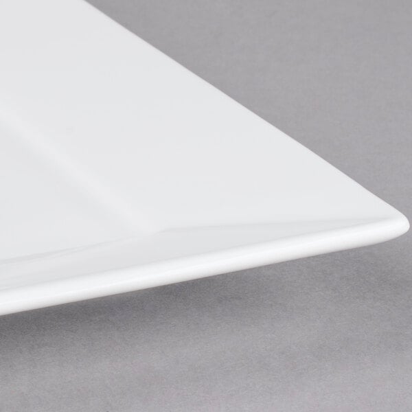 A close up of a white Arcoroc square porcelain plate.