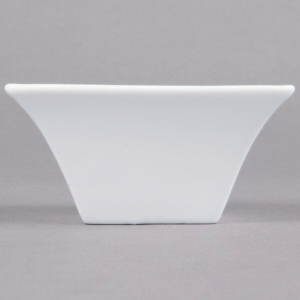 A white square Arcoroc flared bowl on a gray surface.