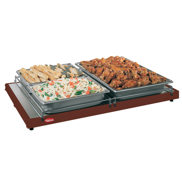 A Hatco Glo-Ray heated shelf with trays of food on it.