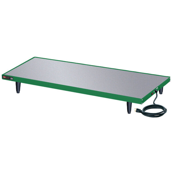 A green and silver rectangular Hatco heated shelf on a table with a cord.