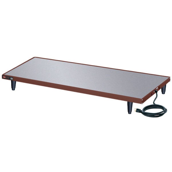A rectangular Hatco heated shelf on a table with a cord.
