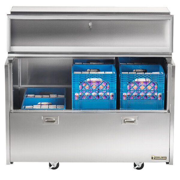 A stainless steel Traulsen milk cooler with blue bins inside.
