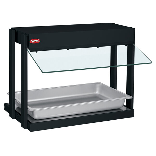 A black Hatco Mini-Merchandising Warmer with a glass shelf on a counter.