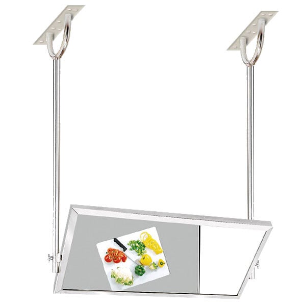 An Advance Tabco ceiling mounted tilting demo mirror over a metal table with a cutting board of different colored peppers.