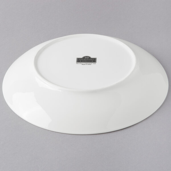 A white porcelain shallow coupe bowl with a black label on it.