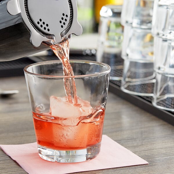 A bartender pouring a drink into an Anchor Hocking Clarisse cocktail glass.