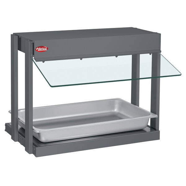 A Hatco mini-merchandising warmer with a glass shelf over a metal container.