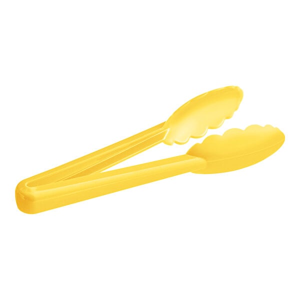 A pair of yellow tongs with scalloped edges.