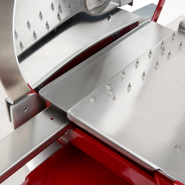 A Berkel meat slicer with silver blades and a red handle.