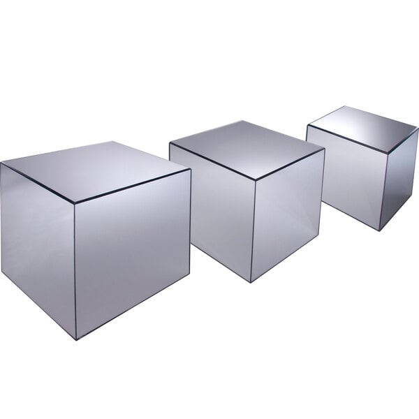 A group of Cal-Mil glass cubes with mirror surfaces on a table.