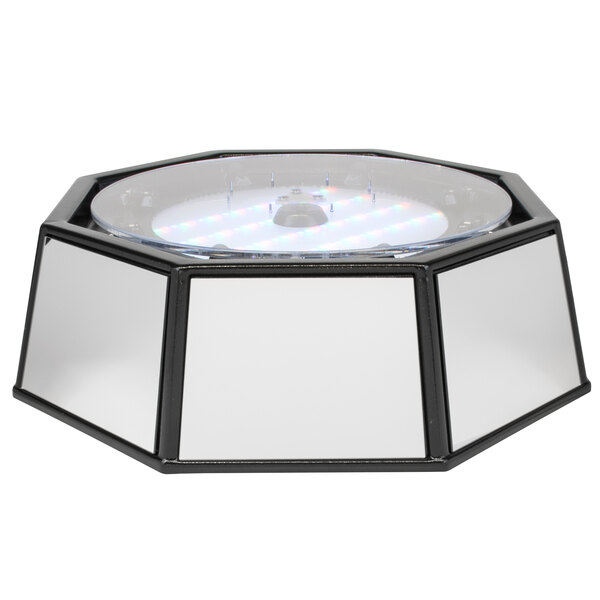 A circular white mirror with a circular white top on a table.