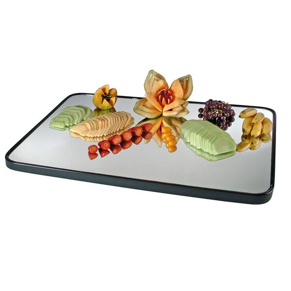 A Cal-Mil rectangular mirror tray with fruit cut into flowers on it.