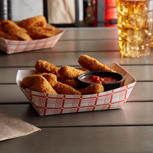 A red check paper food tray filled with fried chicken and dipping sauce.