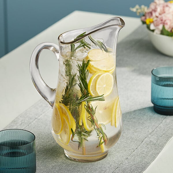 A Libbey glass pitcher filled with water, lemons, and rosemary.