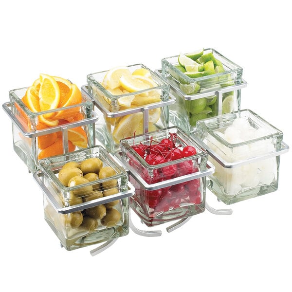 A Cal-Mil platinum wire display with glass containers of fruit and olives.