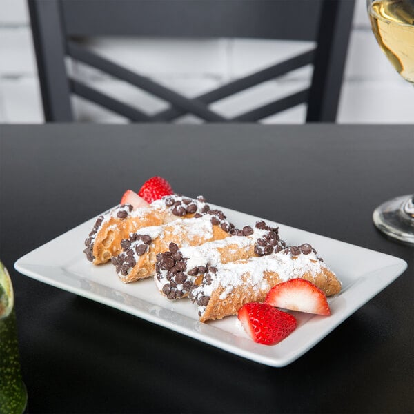 A TuxTrendz bright white rectangular china plate with pastries and strawberries on it.