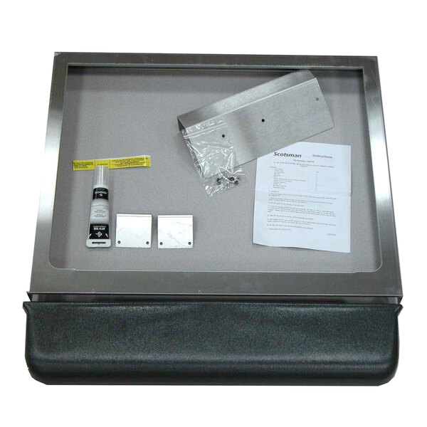 A Scotsman adapter kit in a metal box on a metal tray with a piece of paper.