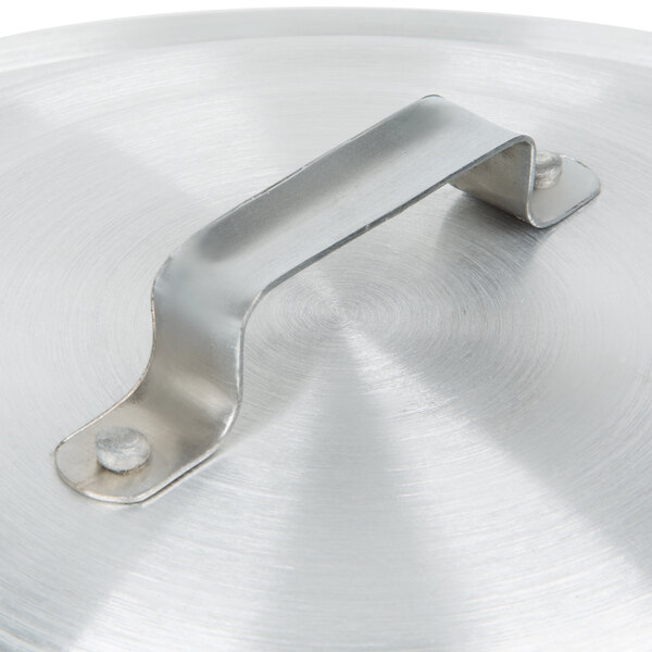 A metal lid with an aluminum handle.