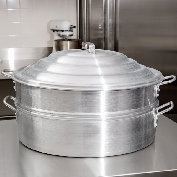 A close-up of a Town aluminum steamer cover on a large metal pot.