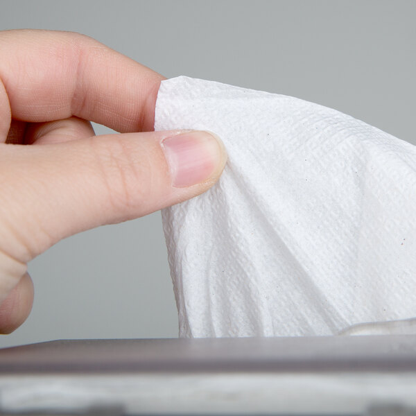 A hand holding a white tissue paper.