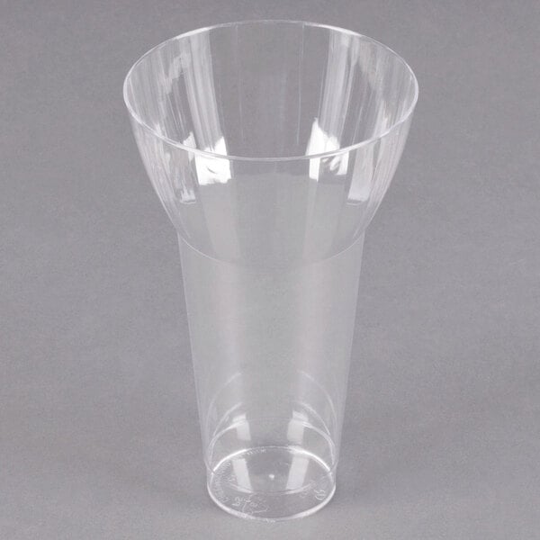 A clear plastic WNA Comet parfait cup on a gray surface.