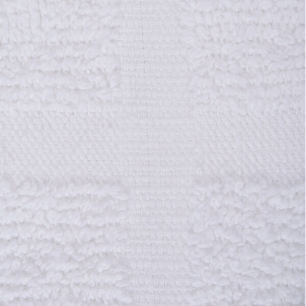 A close up of a white fabric bath mat with a pattern.
