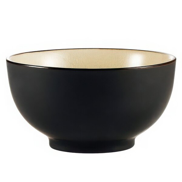 A black bowl with a creamy white interior and a black non-glare exterior.